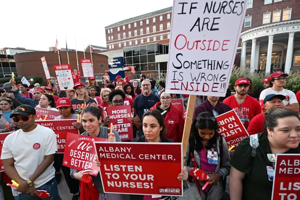 Crowd of nursese holding sign outside Albany Med